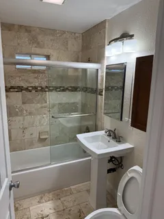 a bathroom with a sink a toilet and shower