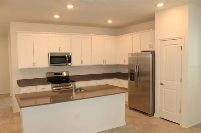 a kitchen with stainless steel appliances a refrigerator a stove a microwave and cabinets