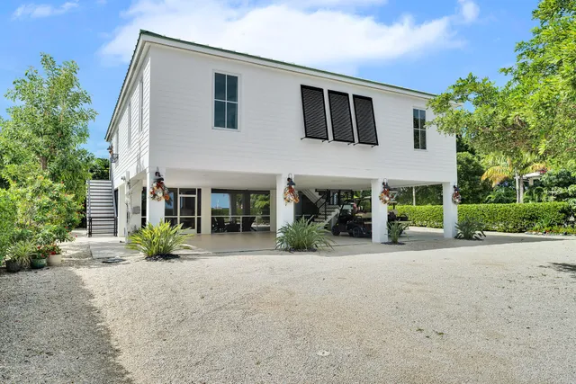 a front view of house with yard and trees around