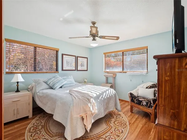 a bedroom with a bed a dresser and a large window