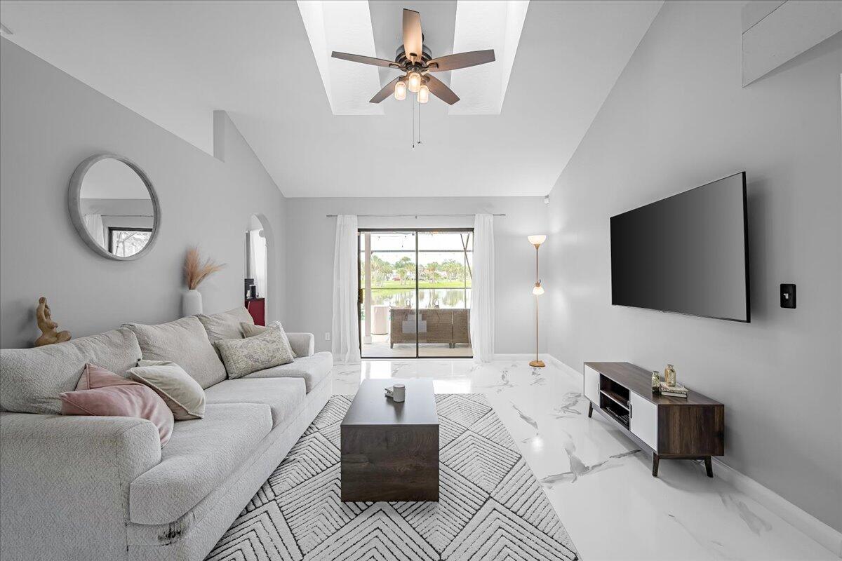 1901 Jacques Drive Melbourne, FL 32940 - Photo 12 of 43 a living room with furniture a flat screen tv and a large window