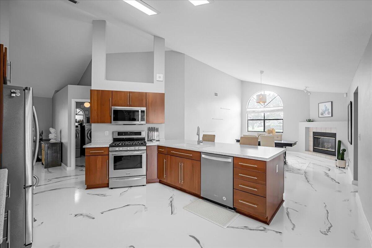 1901 Jacques Drive Melbourne, FL 32940 - Photo 19 of 43 a kitchen with stainless steel appliances granite countertop a stove top oven a sink dishwasher a dining table and chairs with wooden floor