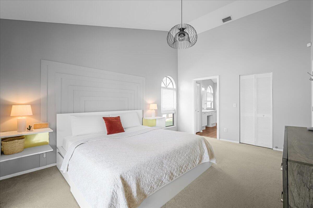 1901 Jacques Drive Melbourne, FL 32940 - Photo 34 of 43 a bedroom with a large bed and a chandelier