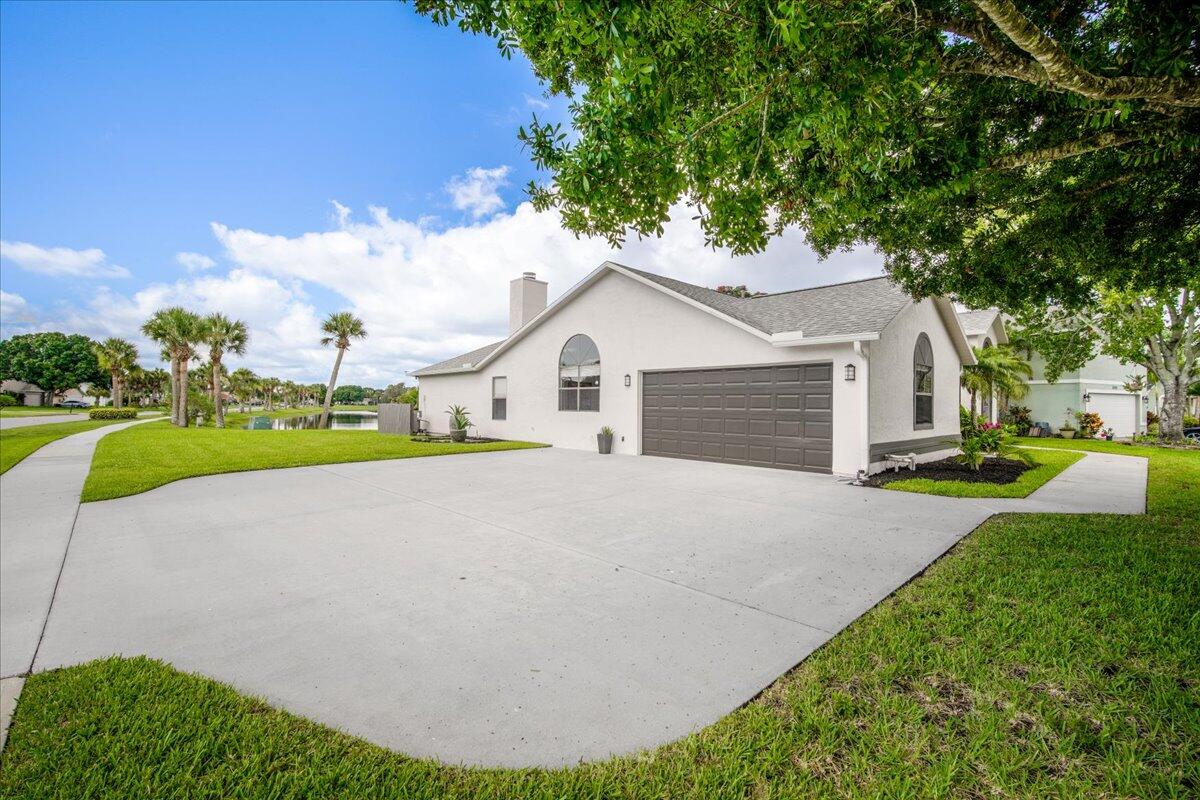 1901 Jacques Drive Melbourne, FL 32940 - Photo 8 of 43 a white house with a small yard and big trees