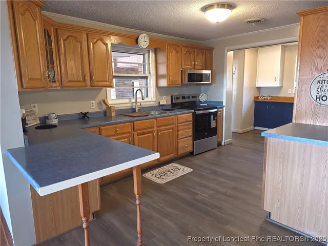 a kitchen with stainless steel appliances granite countertop a sink dishwasher stove refrigerator and microwave
