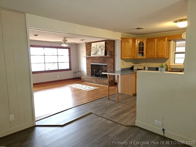 a living room with stainless steel appliances granite countertop a refrigerator a stove and a window