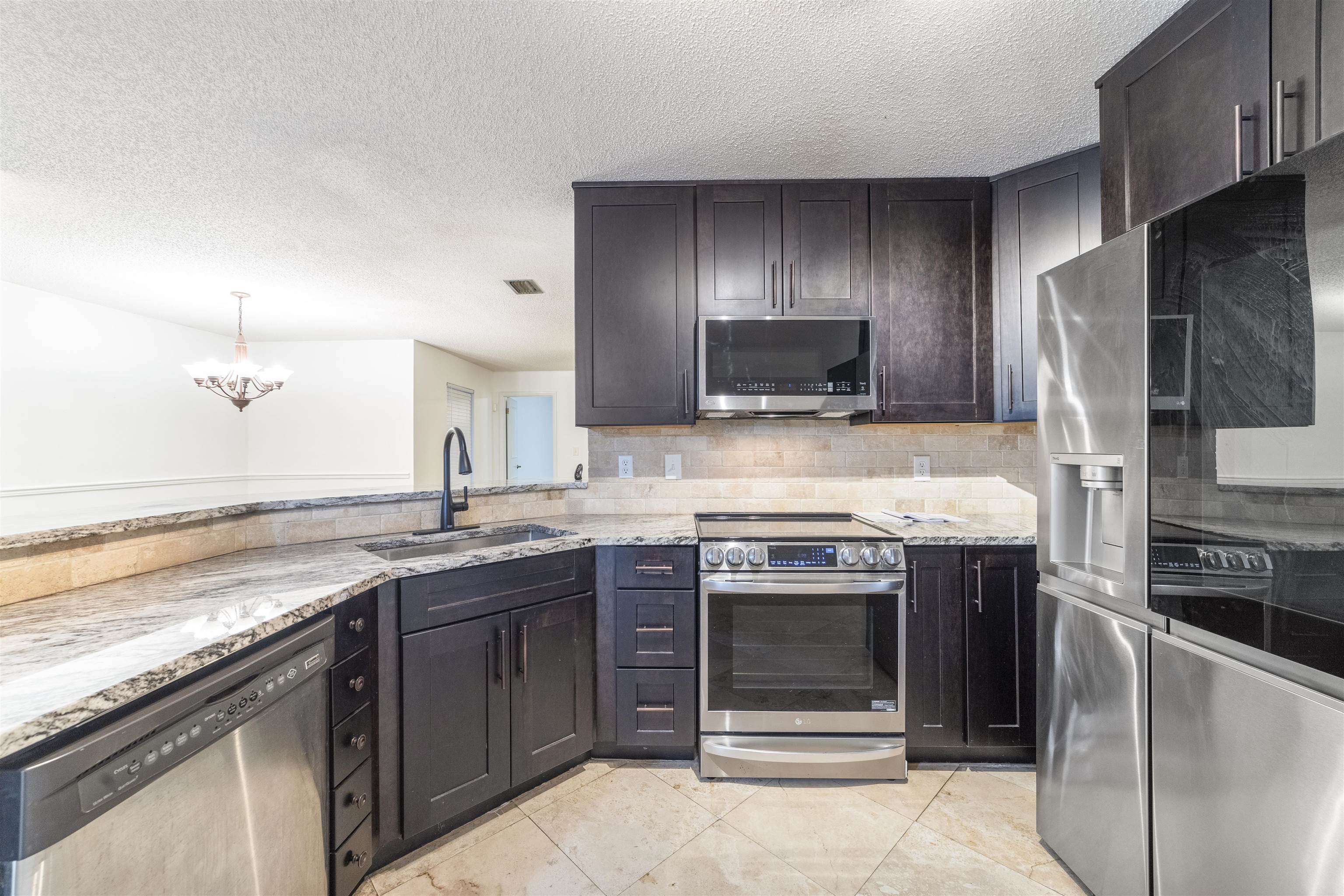 111 Lobelia Road St. Augustine, FL 32086 - Photo 17 of 46 a kitchen with stainless steel appliances granite countertop a stove sink and refrigerator