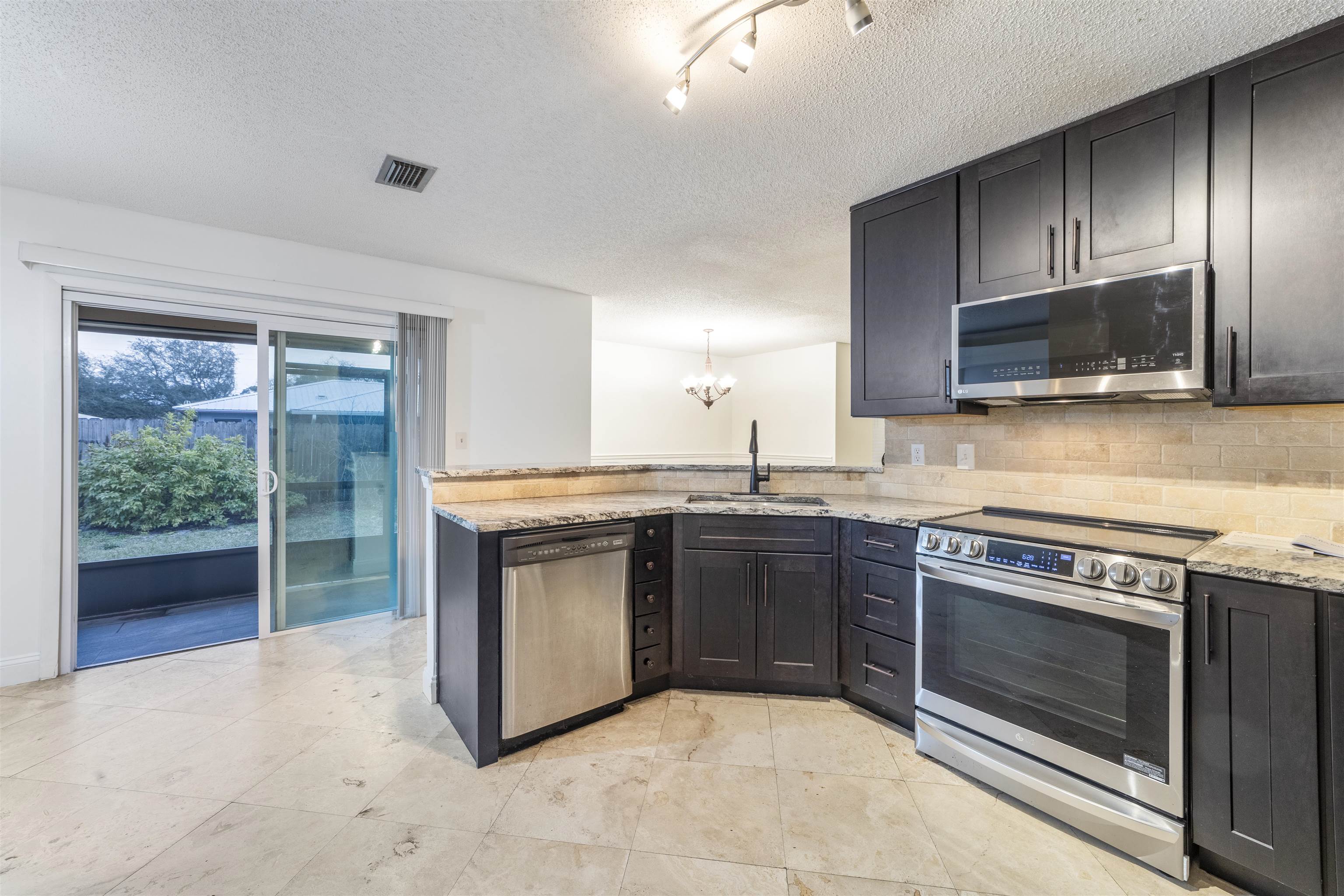 111 Lobelia Road St. Augustine, FL 32086 - Photo 19 of 46 a kitchen with granite countertop a stove and a microwave oven