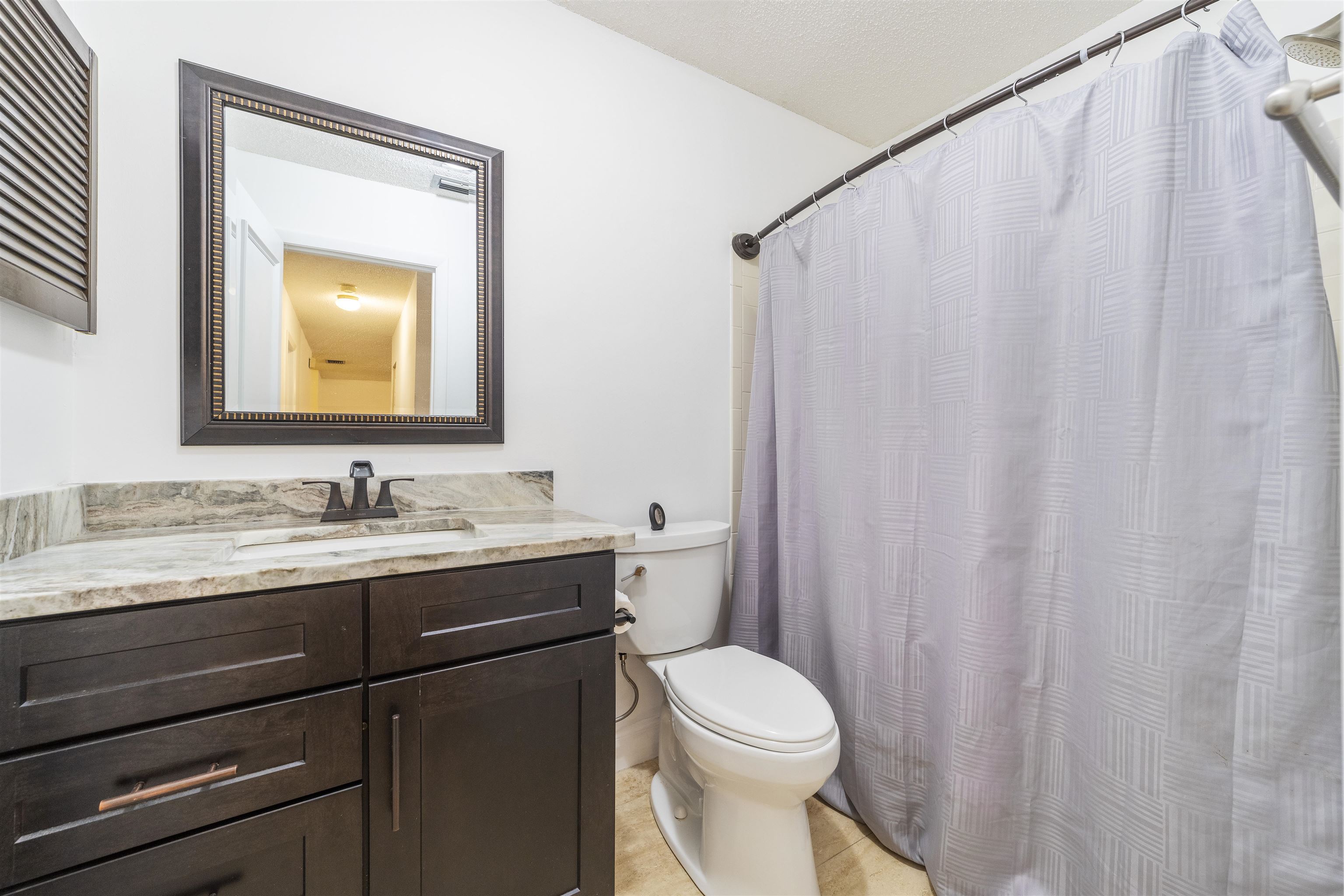 111 Lobelia Road St. Augustine, FL 32086 - Photo 35 of 46 a bathroom with a granite countertop sink a toilet and a mirror