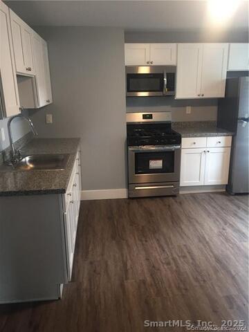 102 Lombard Street, Unit 1 New Haven, CT 06513 - Photo 3 of 7 a kitchen with granite countertop a stove and a wooden floor