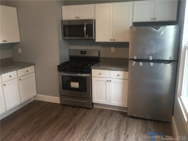 a kitchen with a refrigerator stove and white cabinets