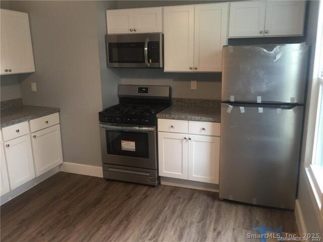 102 Lombard Street, Unit 1 New Haven, CT 06513 - Photo 4 of 7 a kitchen with a refrigerator stove and white cabinets