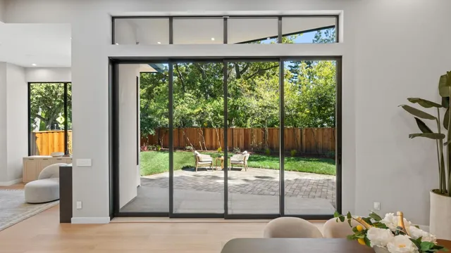 a view of chair and table in backyard with wooden fence