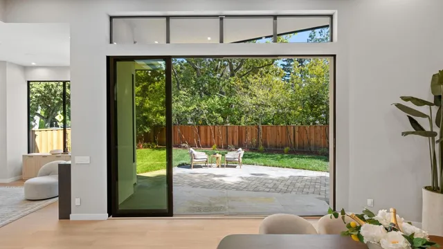 a dining room with stainless steel appliances kitchen island granite countertop a table chairs and a refrigerator