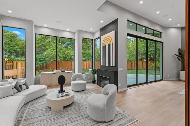 a living room with furniture large window and wooden floor