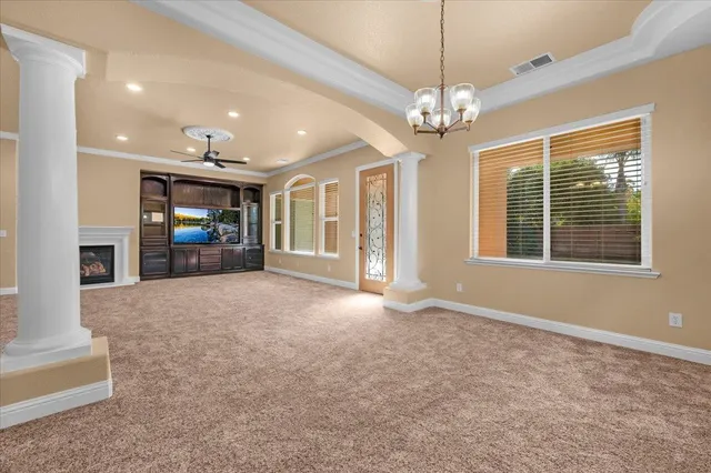 a view of empty room with a window and chandelier
