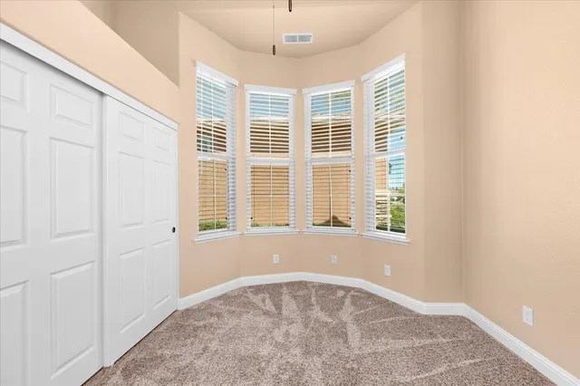 an empty room with windows and fan