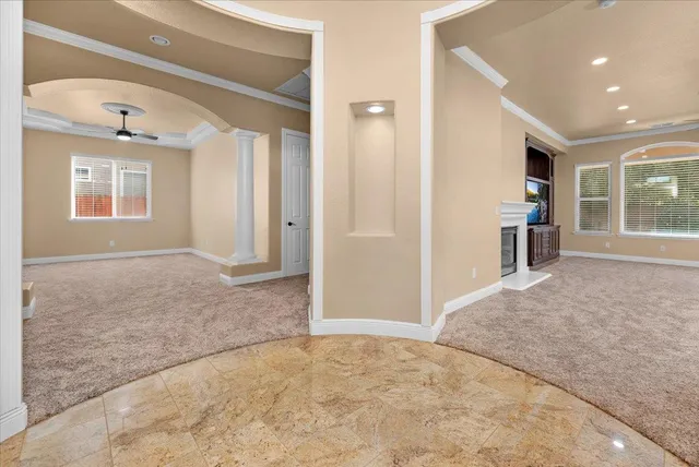 an empty room with kitchen view and windows