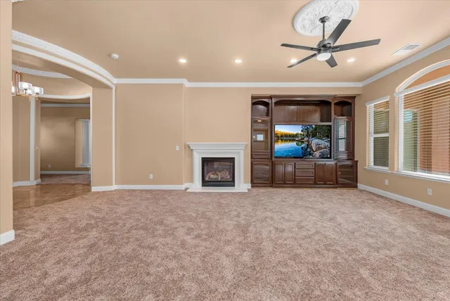 a view of a livingroom with a kitchen and a ceiling fan