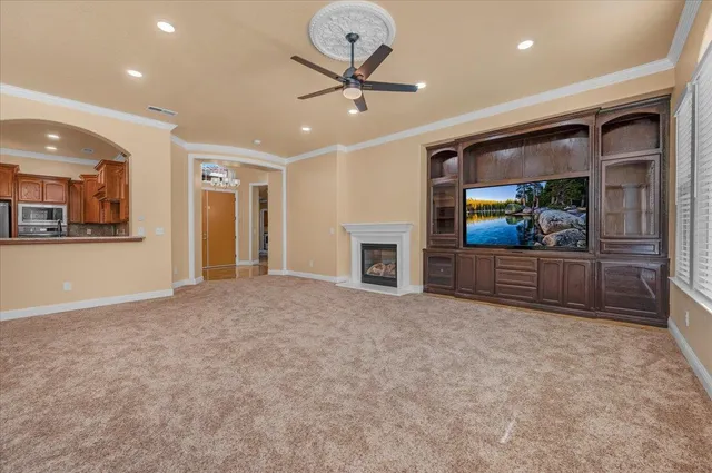 a view of an empty room with a fireplace and a chandelier