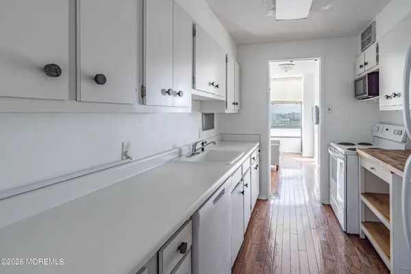 a kitchen with white cabinets and appliances