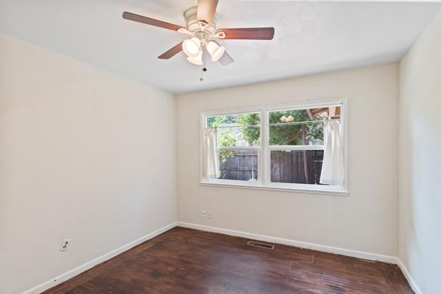 an empty room with a window and a fan