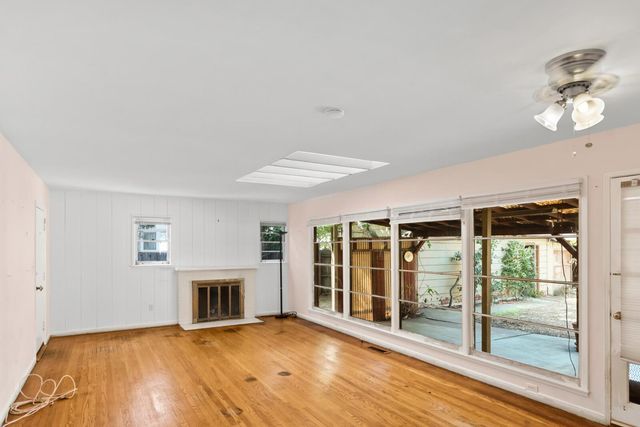 a view of a livingroom with wooden floor and a fireplace