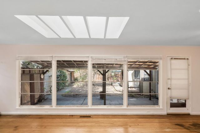 a view of a livingroom with wooden floor and a window