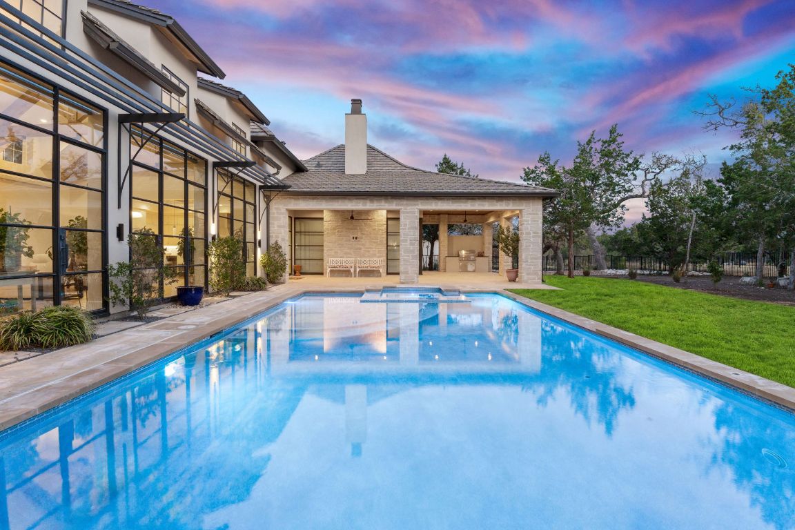 229 Tiffanie Way Austin, TX 78737 - Photo 2 of 40 Pool at dusk with a patio area, a lawn, a pool with connected hot tub, and ceiling fan