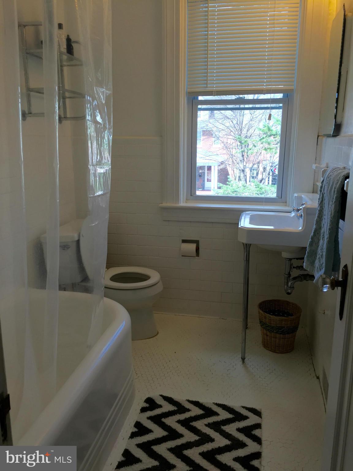 219 Hopkins Road Baltimore, MD 21212 - Photo 14 of 27 a bathroom with a sink a window and a toilet