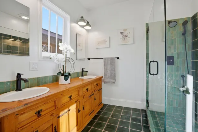 a bathroom with a double vanity sink mirror and shower