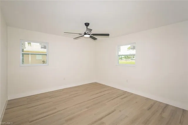 a view of a room with wooden floor and a ceiling fan