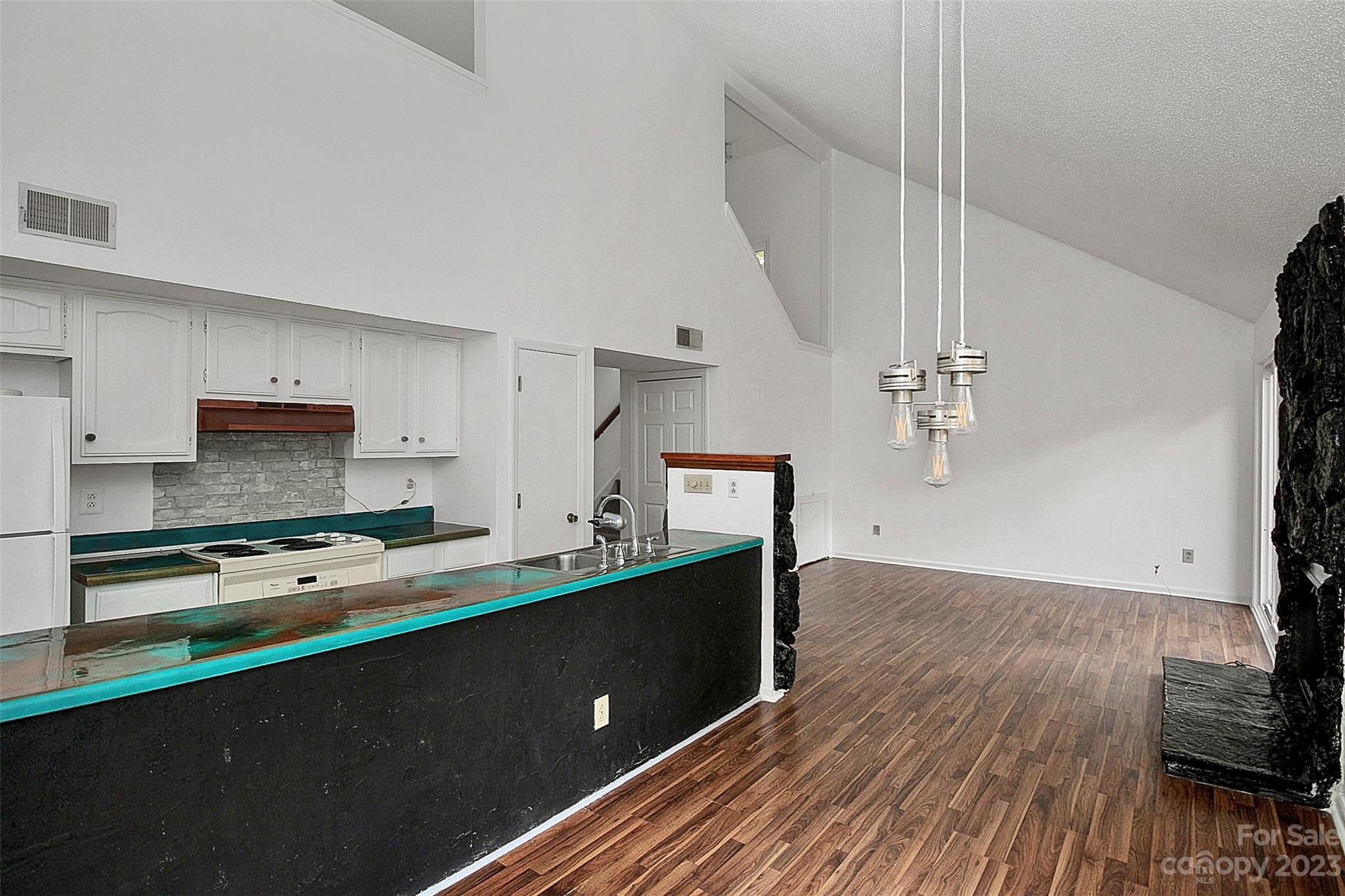27051 Catamaran Drive Tega Cay, SC 29708 - Photo 24 of 35 a kitchen with a wooden floor and a stove