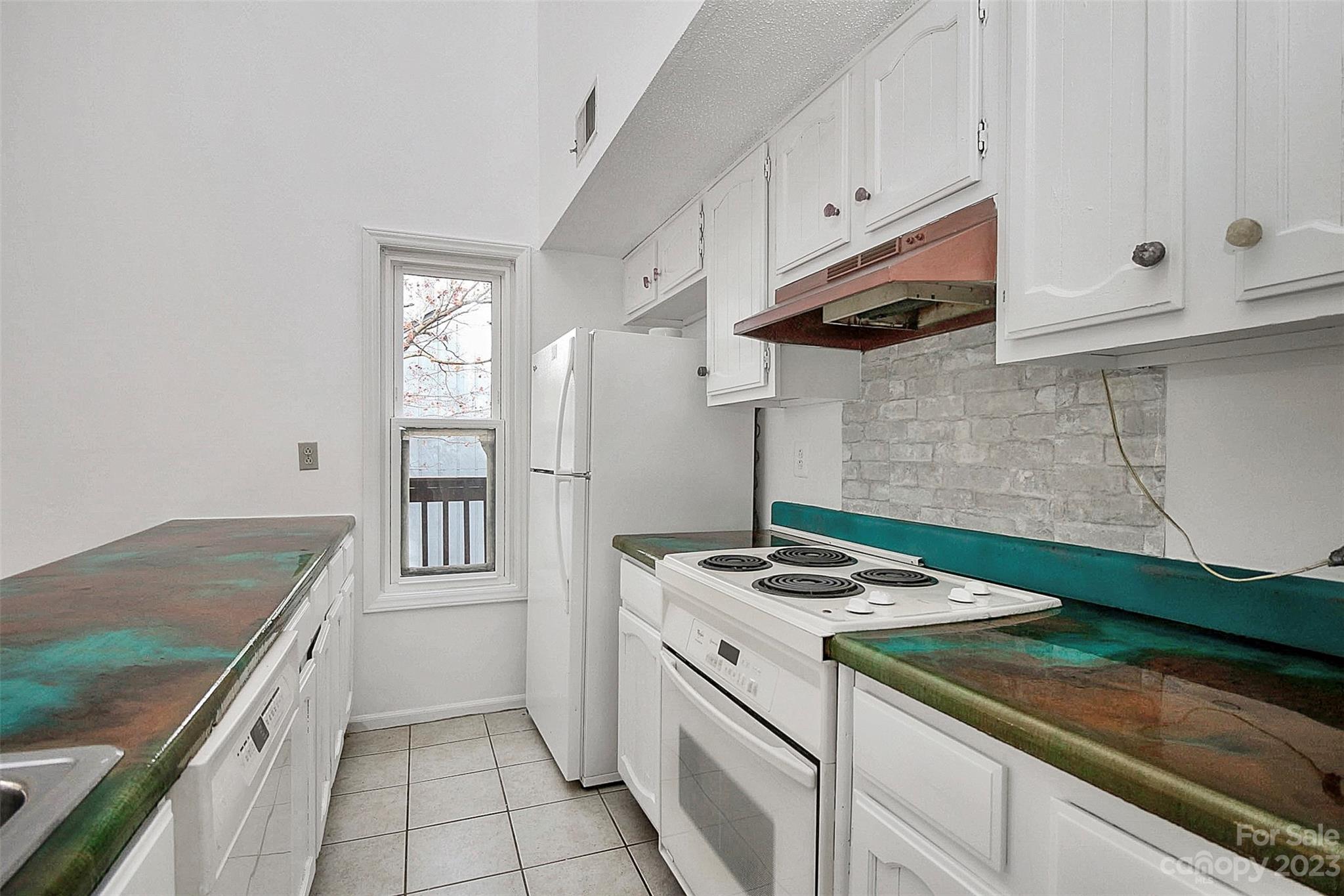 27051 Catamaran Drive Tega Cay, SC 29708 - Photo 28 of 35 a kitchen with granite countertop a sink stove and refrigerator