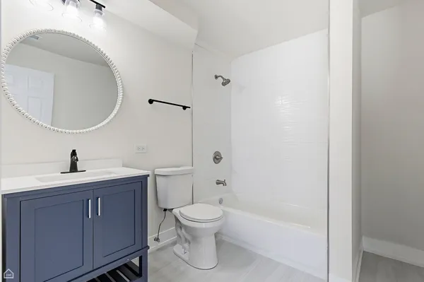 a bathroom with a granite countertop toilet a sink and a mirror