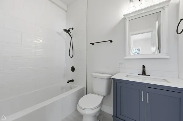 a bathroom with a granite countertop toilet a sink and a bathtub