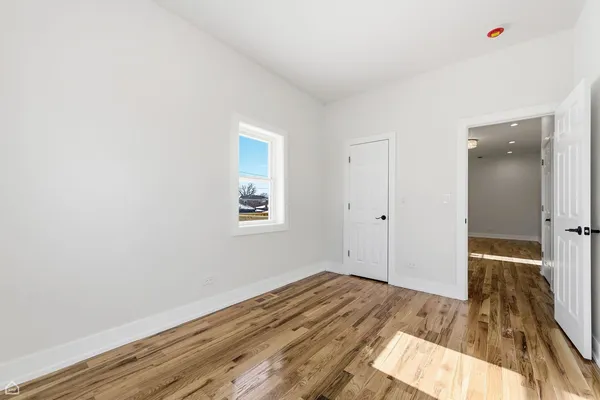 a view of a room with wooden floor and a bathroom