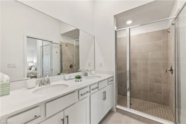 a bathroom with a shower sink vanity granite and mirror
