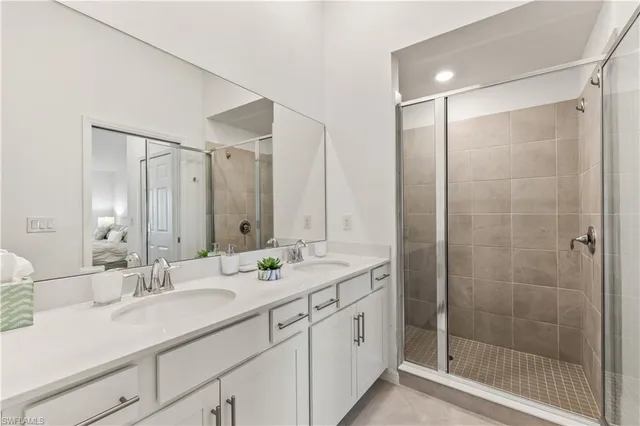 a bathroom with a shower sink vanity granite and mirror