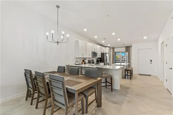 a kitchen with kitchen island stainless steel appliances a dining table and chairs