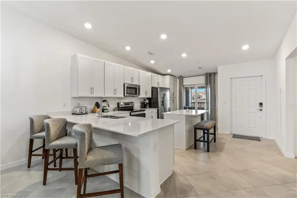 a kitchen with a sink and chairs