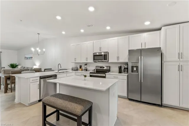 a kitchen with a sink stainless steel appliances and white cabinets