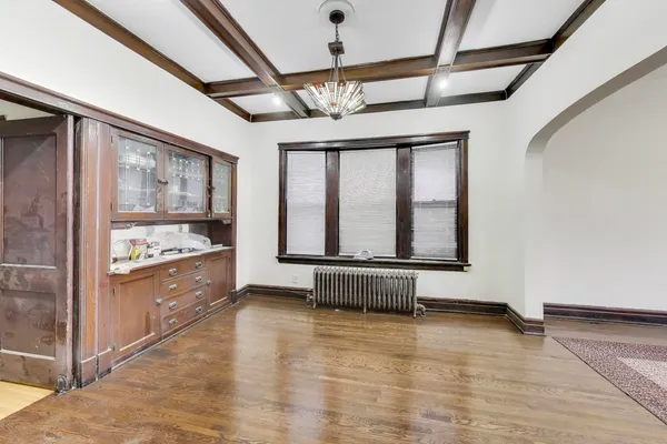 an empty room with wooden floor and ceiling fan
