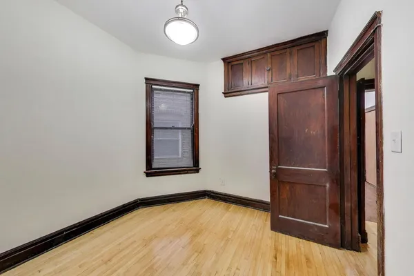 a view of empty room with wooden floor