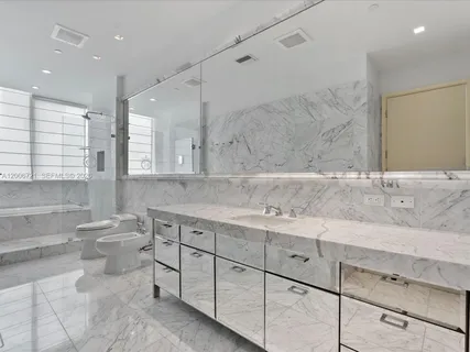 a bathroom with a tub sink and mirror