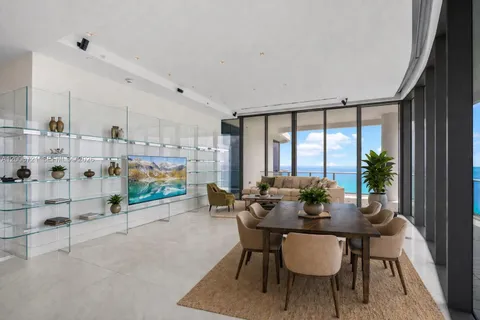 a dining room with furniture and a floor to ceiling window