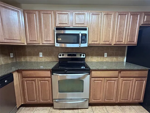 a kitchen with stainless steel appliances granite countertop a stove sink and cabinets