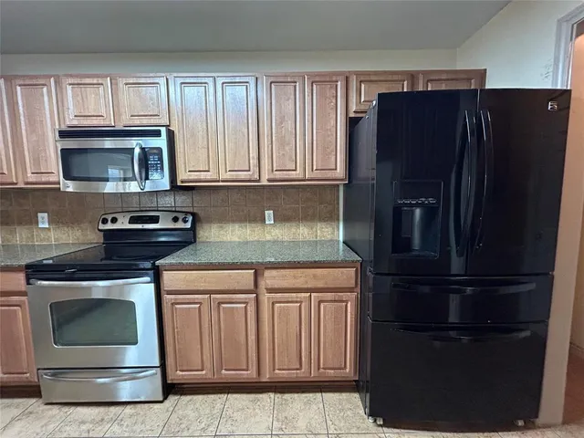 a kitchen with granite countertop white cabinets and stainless steel appliances