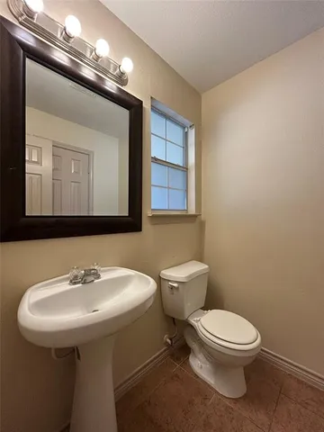 a bathroom with a toilet a sink and mirror