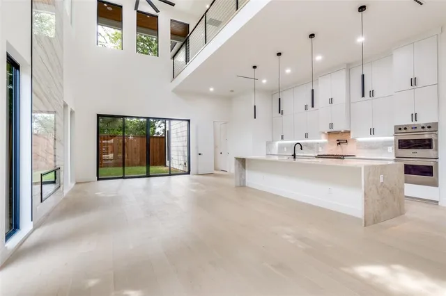 a large white kitchen with a large window
